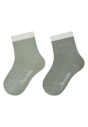 Paar gerippte, hellgrüne Knöchelsocken mit weißen Bündchen, jeweils mit einem kleinen weißen Markenlogo im Zehenbereich.