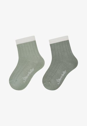 Paar gerippte, hellgrüne Knöchelsocken mit weißen Bündchen, jeweils mit einem kleinen weißen Markenlogo im Zehenbereich.