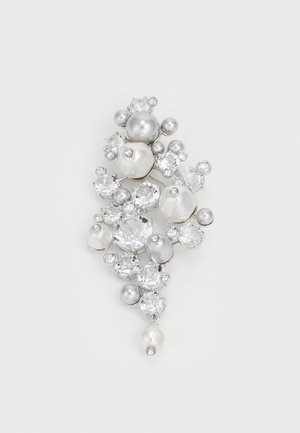 Broche com um grupo de pérolas em prata, cinza e branca de vários tamanhos, intercaladas com strass transparentes, montadas em metal de tom prateado.