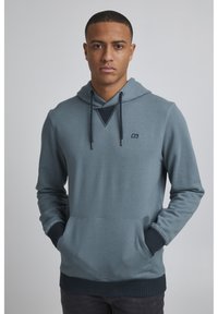 Sudadera con capucha en tejido azul grisáceo, con un bolsillo frontal, puños y dobladillo de canalé, con un pequeño logo en el pecho y un escote texturizado.
