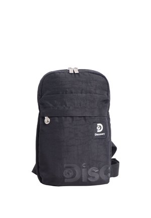 Schwarzer rechteckiger Rucksack mit vorderer Reißverschlusstasche, silbernen Reißverschlussanhängern und Discovery-Logo-Patch oben rechts vorne.