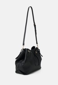 Černá kožená kabelka s texturovaným povrchem, která má splétanou rukojeť, nastavitelný popruh a zlaté kovové detaily.