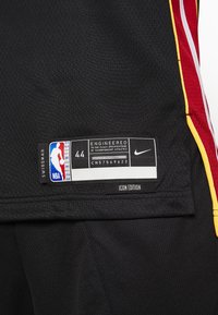 Crna mrežasta košarkaška majica s naglascima u žutoj, crvenoj i bijeloj boji. Sadrži oznaku "SWINGMAN", veličina 44, i Nike logo.