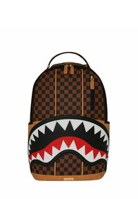Mochila de lona a cuadros marrón con un dise�ño de cara de tiburón en blanco y negro, acentos rojos y fondo de cuero sintético marrón. Cuenta con doble cremallera.