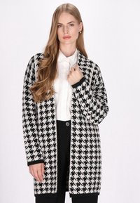 Schwarzer und weißer Hahnentrittmuster-Cardigan aus gestricktem Stoff, mit lockerer Passform, langen Ärmeln und offenem Frontdesign.
