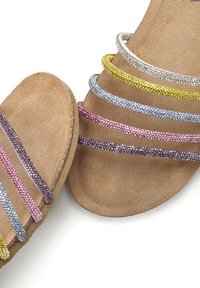 Sandali luccicanti multicolori con una base in suede. Caratterizzati da cinque sottili cinghie accentate da glitter in rosa, viola, giallo e argento.