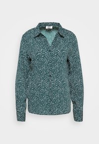 Camicia a maniche lunghe con colletto di un verde scuro a tinta unita, decorata con un motivo a pois bianchi. Presenta una chiusura con bottoni sul davanti e un taglio morbido con maniche con polsini.