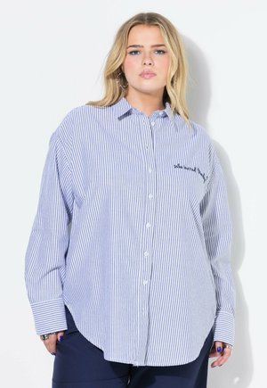 Camisa de botones a rayas azul y blanca con mangas largas, dobladillo redondeado y texto bordado en el pecho. Fabricada en tela ligera.