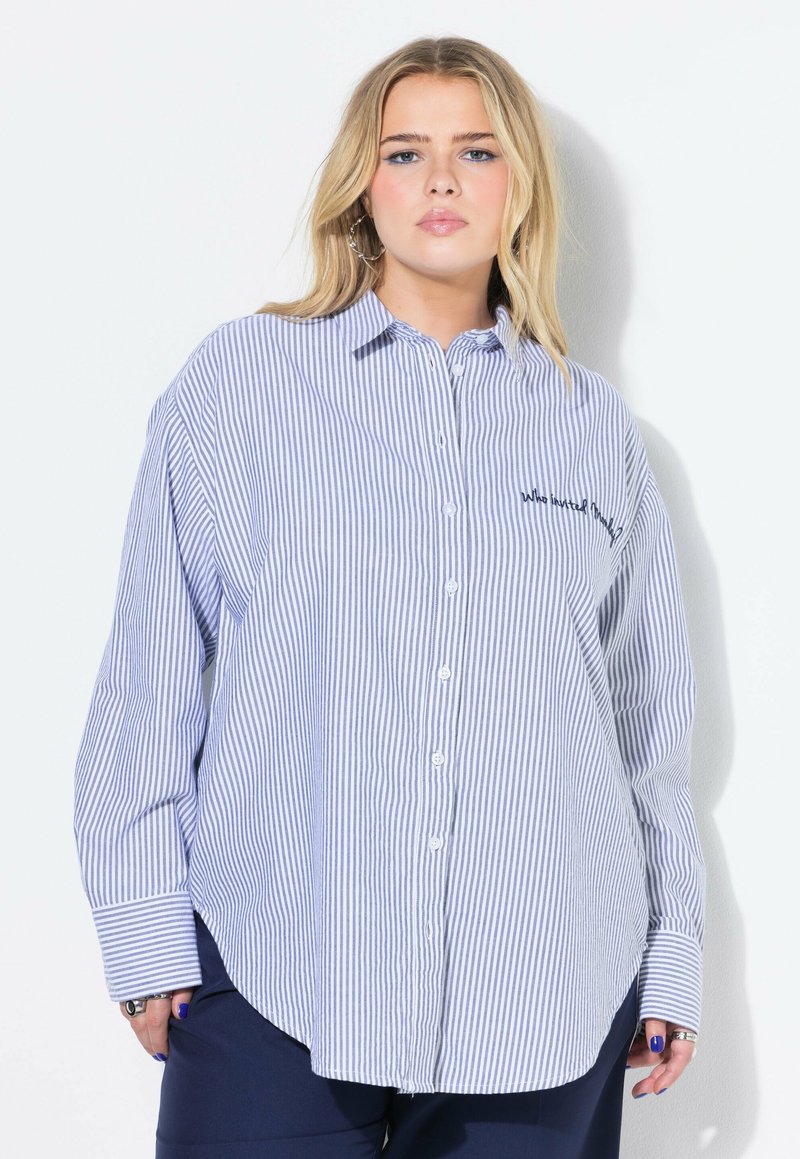 Camicia a righe blu e bianche con bottoni, maniche lunghe, orlo arrotondato e testo ricamato sul petto. Realizzata in tessuto leggero.