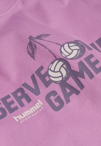 Lila Baumwoll-T-Shirt mit einem Grafikdruck von Kirschen und Volleyballs, mit auffälligem Text "SERVE" und "GAME" in dunkler Schrift.