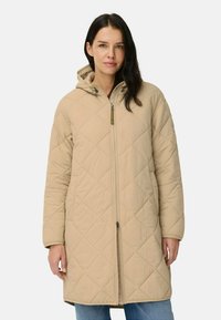 Beige vatteret lang frakke med lynlåslukning og justerbar hætte. Har struktureret diamantmønster og sidelommer.