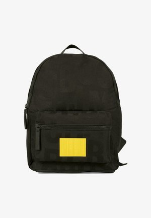 Zwarte stoffen rugzak met een afgeronde vorm, voorzien van een gestructureerde gele patch en een voorzak met rits. Subtiel patroon dat in het materiaal is gedrukt.