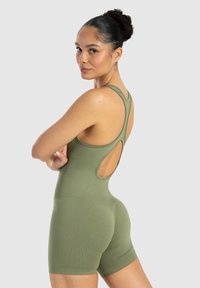 Monosuit deportivo verde oliva con la espalda semiabierta, tirantes anchos y pantalones cortos ajustados. El material parece suave y elástico, diseñado para la comodidad.