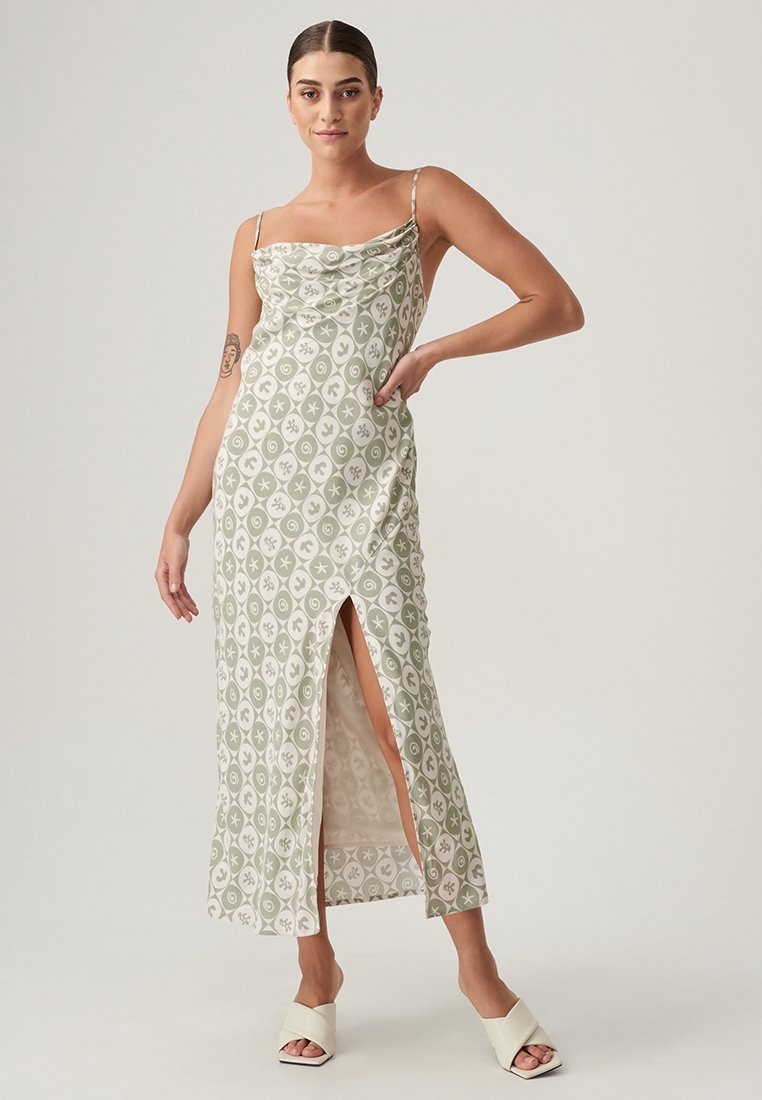 Maxi abito verde e bianco con motivo, scollatura a cowl, spalline sottili e spacco laterale; realizzato in tessuto morbido con una leggera lucentezza.