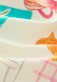 Katoenen stof met kleurrijke patronen in oranje, roze en teal, weergegeven in zachte plooien. De textuur lijkt glad en licht glanzend.