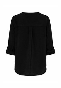 Haut noir à coupe décontractée, col rond, manches trois-quarts retroussées aux poignets, tissu texturé et détail de pli au centre du dos.