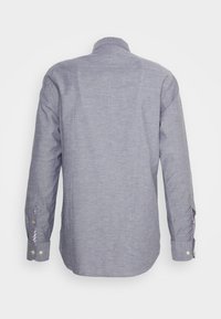 Camicia azzurra a maniche lunghe con bottoni vista da dietro, con colletto e polsini abbottonati, texture liscia e orlo leggermente curvo.