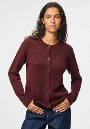 Cardigan bordeaux en tissu texturé, avec un col rond, des manches longues et une fermeture à boutons sur le devant.