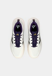 Weiße Sportschuhe mit einer strukturierten Oberseite, schwarzen Streifen, lila Akzenten und dunklen Schnürsenkeln. Mit einer Gummisohle und einem gepolsterten Kragen.