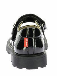 Sandal in pelle verniciata nera con cinturino regolabile, suola in gomma e logo rosso "Kickers" di lato. Soletta texturizzata per il comfort.
