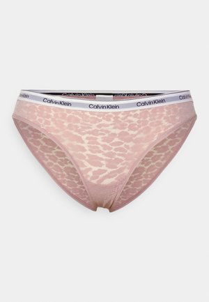 Różowe koronkowe stringi z białą elastyczną talią z logo Calvina Kleina. Teksturowany wzór na całej powierzchni materiału.
