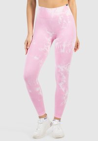 Leggings rosa con un motivo tie-dye bianco, presentano una vita alta e una texture liscia e elastica.
