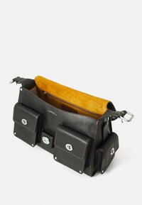 Black leather bag with yellow suede lining, featuring three front pockets and silver hardware. Visible stitching accents on edges.