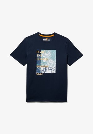 Laivastonsininen lyhythihainen T-paita, jossa puun oksien grafiikkaa ja teksti "Plant the Change" sekä "Nature Needs Heroes" edessä.