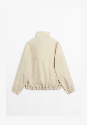 Beżowa kurtka z wysokim kołnierzem, długimi rękawami i elastycznymi mankietami oraz elastycznym dołem, pokazana od tyłu na białym tle.