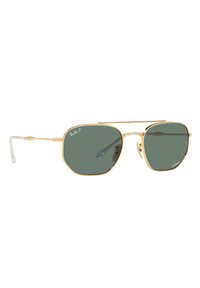 Occhiali da sole in metallo dorato con lenti verdi ottagonali. Presentano un design con doppio ponte e punte delle aste trasparenti per il comfort. Marchio Ray-Ban visibile.