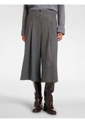 Grau gerippte, weit geschnittene, verkürzte Hose getragen mit dunkelbraunen kniehohen Lederstiefeln und einem passenden grauen Pullover.