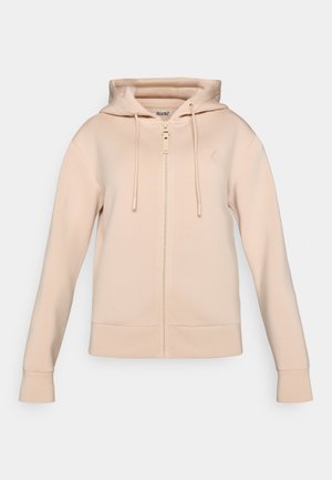 Lysebeige hettegenser med glidelås, snøring på hetten, frontlommer og ribbestrikkede mansjetter. Laget av mykt stoff med glatt tekstur.