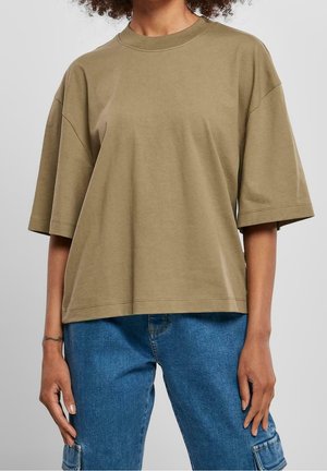 Oliwkowa, bawełniana koszulka z krótkim rękawem o luźnym kroju i okrągłym dekolcie, charakteryzująca się gładką fakturą i minimalistycznymi detalami szycia.