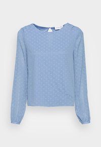 Blusa a maniche lunghe blu chiaro con un motivo a pois testurizzato, scollatura rotonda e dettaglio a occhio di bue sul retro. Tessuto morbido e leggero.