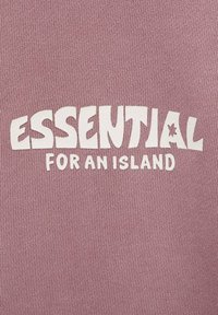Tessuto lilla chiaro con una trama a coste, caratterizzato da una stampa bianca audace che recita "ESSENZIALE PER UN'ISOLA". Accento di stella notevole nel testo.