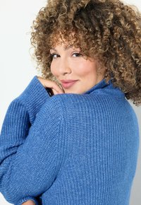 Blauer gerippter Strickpullover mit hohem Kragen und locker sitzenden Ärmeln. Bietet eine weiche Textur und eine entspannte Silhouette.