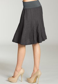 Grauer Leinenrock mit elastischem Bund, weit ausgestelltem Design und knielanger Schnitt; kombiniert mit beigen High Heels.