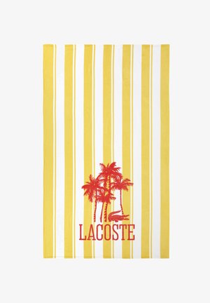 Gelb-weiß gestreiftes Handtuch mit roten Palmen, einem Krokodil und dem roten Schriftzug "LACOSTE" in der unteren Mitte.