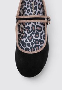 Zapato Mary Jane de ante negro con suela plana, presenta una correa estrecha con una hebilla plateada y una plantilla de estampado de leopardo.