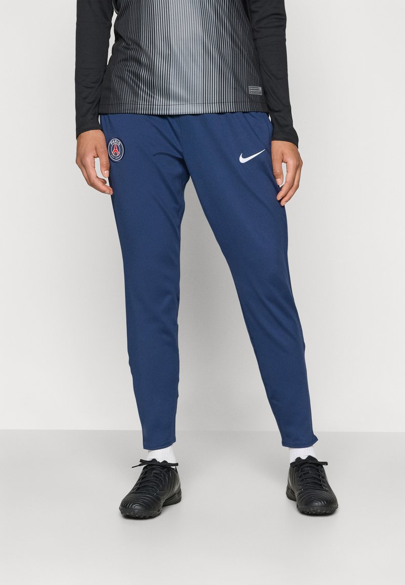 Marina atletiska byxor med slim fit, med en vit Nike-logotyp och Paris Saint-Germain-märke på vänstra låret. Slätt, syntetiskt material.