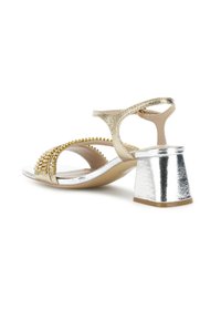 Zlaté sandály s korálkovou ozdobou, metalický stříbrný blokový podpatek, design s otevřenou špičkou, nastavitelné zapínání na kotníku a hladký povrch.