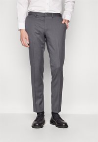 Gray tailored trousers with a slim fit, made of smooth fabric. Features a flat front, side pockets, and belt loops. Paired with black shoes.