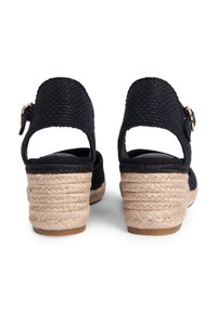 Μπλε ναυτικό τακούνι εσπαντρίγια με υφαντό επάνω μέρος, ανοιχτή πλάτη και λουρί στο αστράγαλο. Φυσικό τακούνι πλατφόρμα τυλιγμένο με τζούτ με υφή στην επιφάνεια.