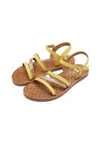 Sandalias amarillas con múltiples tiras planas, incluida una tira dorada brillante; plantilla texturizada marrón con patrones de estrellas; cierre ajustable con hebilla.