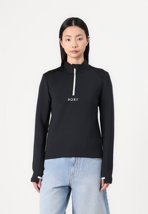 Black long-sleeve top with a high collar and a half-zipper. Features a textured fabric and a white "ROXY" logo on the front.