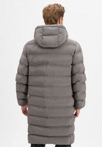 Szara pikowana kurtka puchowa z kapturem, o fakturowanej, pikowanej powierzchni i długim fasonie. Rękawy są lekko bufiaste, a materiał ma połyskujące wykończenie.