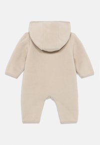 Beige fleeced tuinpak met een capuchon, lange mouwen en zonder voetjes. Zachte textuur en eenvoudige stikseldetails.