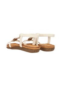 Sandales blanches avec des sangles tissées, une semelle intérieure rembourrée et une semelle en caoutchouc brun. Présente une texture douce et un design minimaliste.