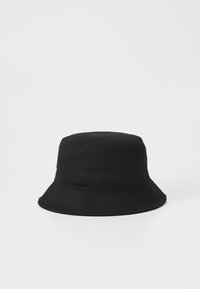 Black bucket hat made of cotton. Features a round, structured crown and a wide, downward-sloping brim with stitched detailing.