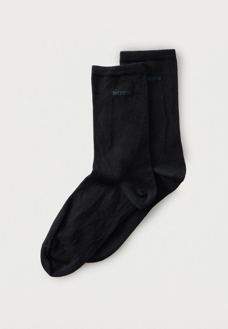 Paire de chaussettes noires mi-mollet avec le logo "BOSS" près du haut, posées à plat sur un fond blanc.